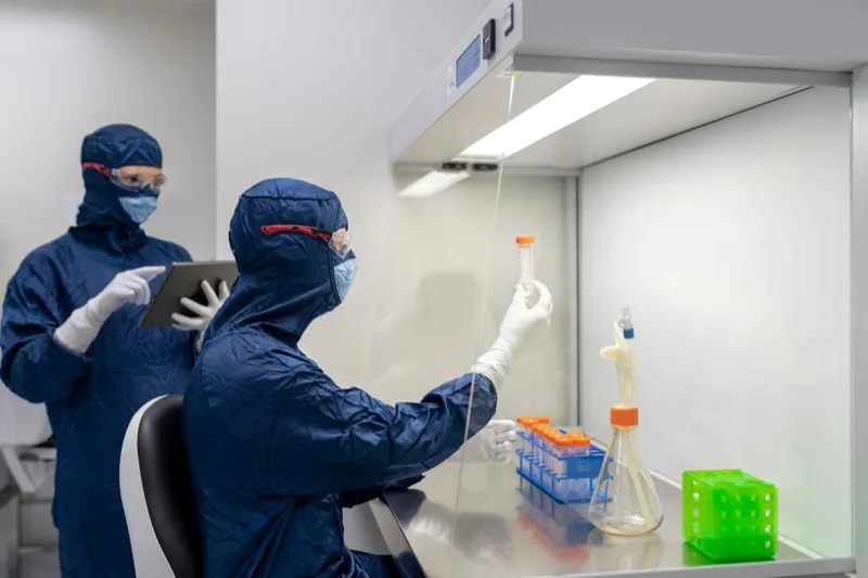Lab technicians conducting quality analysis with tablet and samples